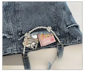 Detail of denim tote bag showing pearl front pocket with bows and storage capacity