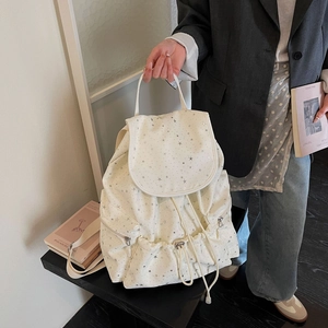 Detail of white star pattern canvas backpack with drawstring closure and side pockets