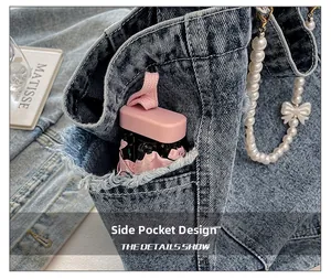 Detail view of denim tote bag side pocket with folding umbrella and pearl strap