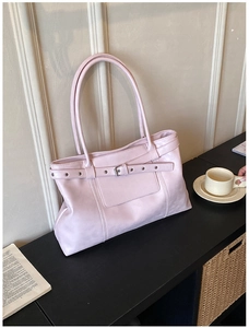 Detail of light pink PU leather tote with metal buckle strap and external patch pocket