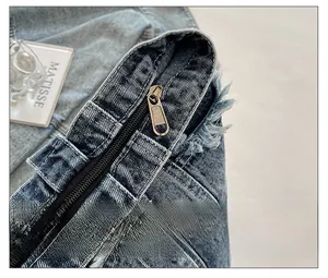 Detail of smooth metal zipper and retro frayed edges on washed denim tote bag