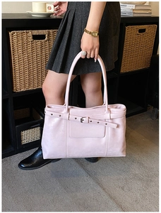 Detail of pink retro tote bag with stylish strap buckle and metallic rivets for women
