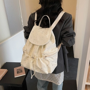Detailed view of the star pattern canvas backpack with drawstring closure and side zipper pocket