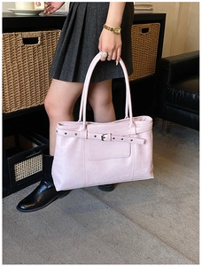 Detail view of pink PU leather tote bag featuring stylish silver buckle and rivet straps