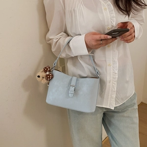 Light blue faux leather underarm bag featuring a cute brown polka dot bear charm