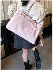 Pink matte leather tote bag with stylish buckle detail shown on a female model