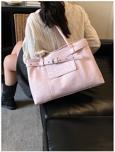 Detail of soft pink tote bag with leather strap buckle and metal eyelet decorations