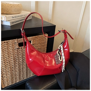 Detail of red glossy patent leather underarm bag with Love & Desire print and charms