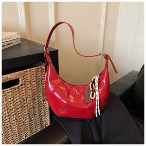Detail of red glossy crescent bag with Love & Desire print and chocolate charm