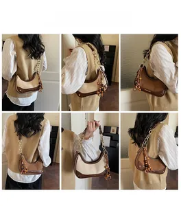 Détail du sac hobo tendance avec couleurs contrastées et pampille en perles de bois