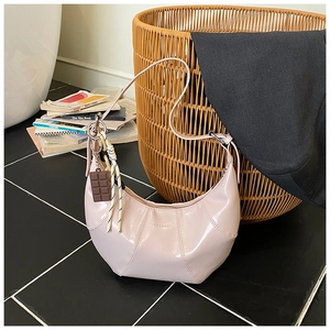 Detail of light pink patent leather crescent bag with chocolate charm and heart branding