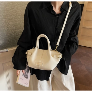 Detailansicht der cremefarbenen Ledertasche mit goldener Schnalle und Umhängeriemen