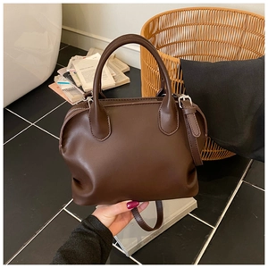 Detail of dark brown matte PU leather shell bag showing soft texture and handle