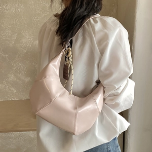 Detail of light pink half-moon hobo bag with braided rope and chocolate pendant decoration