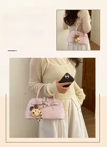 Detailed view of pink satchel bag with double handles and cute plush bear keychain charm