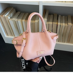 Detaillierte Makroansicht der rosa Lederhandtasche mit goldener Hardware und Markenlogo