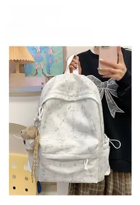 Detailed look at white marble backpack with lightning embroidery and brown plush bear charm