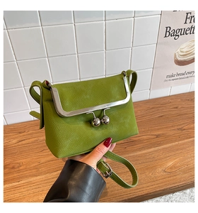 Detailansicht der grasgrünen Umhängetasche aus genarbtem Leder mit Vintage-Kugelverschluss