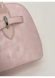 Close-up of pink matte leather texture with pebble grain and silver metal hardware