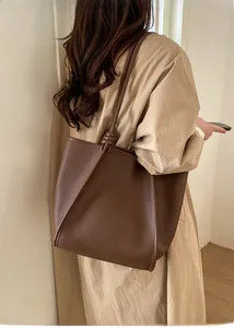 Detail of vintage brown leather tote bag with pebble texture and knotted strap detail