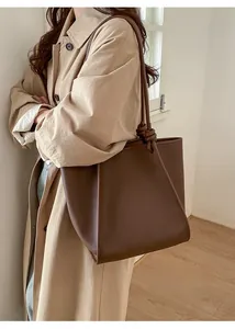 Detail view of dark brown leather tote bag with large capacity and rope knot strap