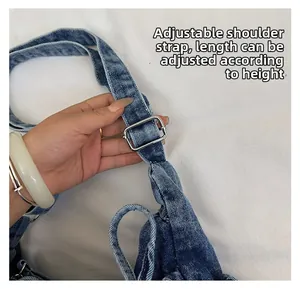 Detail view of denim shoulder bag with adjustable silver metal buckle on the strap