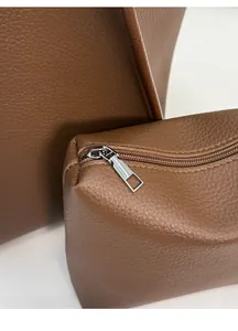 Close-up of brown litchi pattern leather texture and silver metal zipper detail