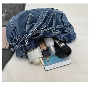 Internal capacity of denim shoulder bag showing tablet, umbrella and daily essentials
