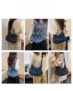 Detail view of denim hobo bag featuring drawstring bow knots in black and blue colors