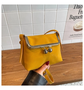 Detailansicht der gelben Lederhandtasche mit Litschi-Maserung und silbernem Kugelverschluss