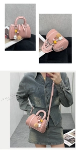 Pink mini Boston bag with lychee texture and cute bear charm shown on a model
