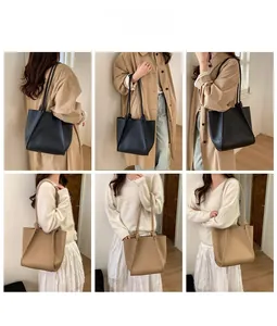Litchi pattern leather tote bag in black and beige displayed on a fashion model