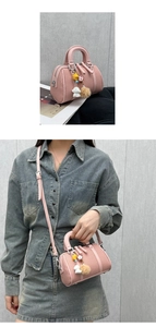 Pink mini Boston bag with mesh texture, colorful charms and crossbody strap detail