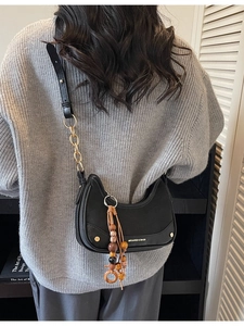 Sac hobo chic en cuir noir avec bandoulière dorée et pompons en perles de bois