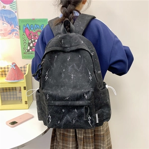 Detail of grey student backpack with white lightning pattern and side storage pocket