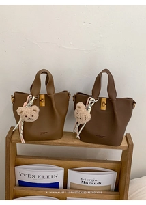 Detail of vintage bucket bags with lychee grain leather and golden turn-lock closure