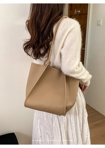 Macro detail of khaki textured leather tote bag featuring a decorative strap knot