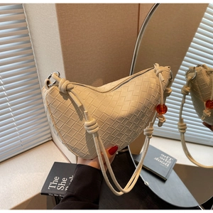 Detail of off-white woven leather hobo bag featuring iconic texture and red bead charm