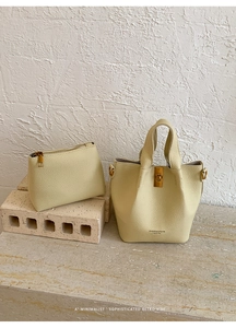Detailed close-up of light yellow litchi pattern leather bucket bag and pouch set