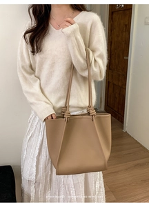 Detail of lychee textured leather tote with unique double knot strap design