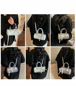 Viste dettagliate della borsa a cilindro a scacchi con fiocchi di pizzo e perle su modella