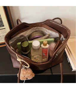 Detail view of large capacity dark brown tote bag interior with storage space and charms