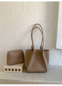 Detail of khaki textured leather tote bag with unique knot handle design and inner pouch