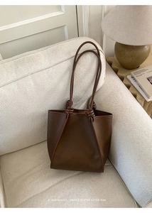 Close-up of the knotted handle detail on this vintage dark brown leather tote bag
