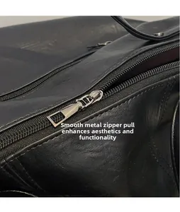 Macro shot of smooth silver hardware zipper pull on black pebbled leather tote bag