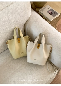 Detail of vintage leather bucket bags in beige and yellow with golden hardware