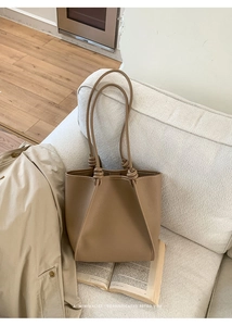 Detail of minimalist retro brown leather tote with unique handcrafted knot shoulder straps
