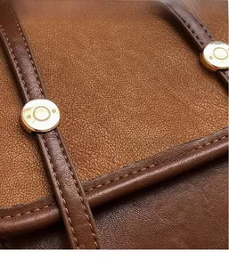 Macro detail of vintage brown contrast backpack featuring lychee leather and gold rivets