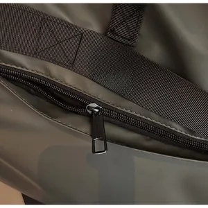 Gros plan sur la fermeture éclair en métal mat et le tissu imperméable du sac fourre-tout