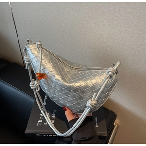 Detail of silver woven leather crescent bag with knot strap and amber bead accent